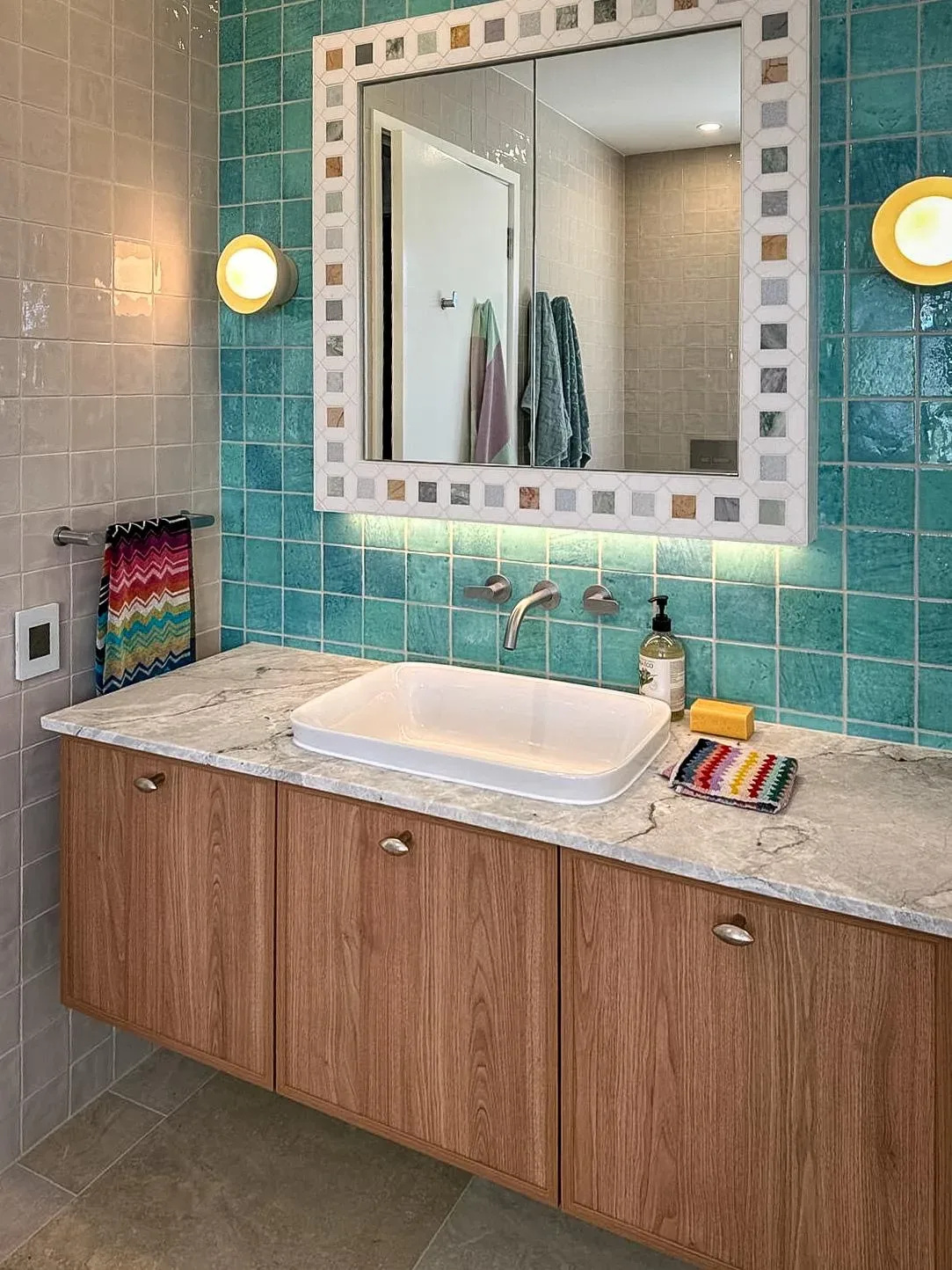 Feature bathroom with teal wall tiles and mosaic trim